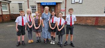 Head teacher Jillian McGown with six pupils outside the main entrance to Ralston Primary School