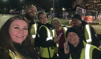 Group of people in high-vis yellow jackets smiling to camera