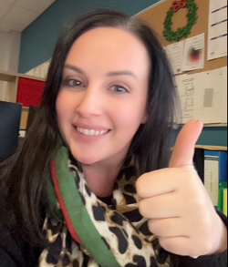 A woman gives a thumbs up to camera