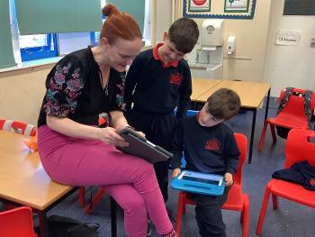 Bishopton Primary teacher with two pupils looking at a tablet